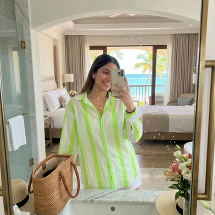 Sagar hill road relaxed cotton shirt with neon green vertical stripes, button-down front, worn by a woman in a hotel